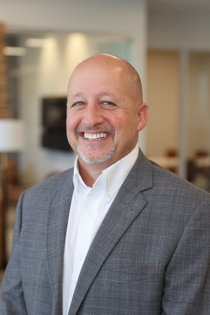 man in gray suit smiling